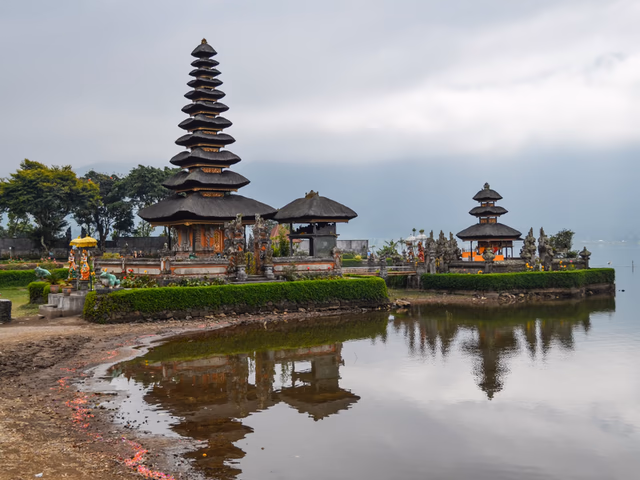 Templo Ulun Danu Beratan sobre el lago Bratan rodeado de montañas y bruma en Bedugul, Bali