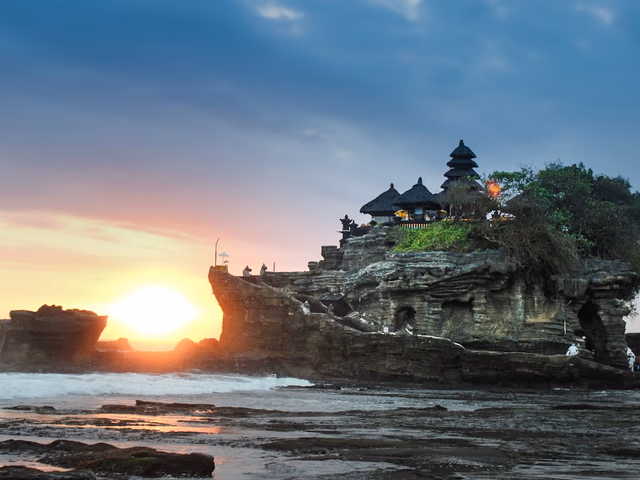 Templo de Tanah Lot sobre formación rocosa en el mar al atardecer, Bali
